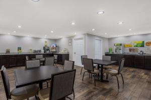 a dining room with tables and chairs and a kitchen at Quality Inn Moultrie in Moultrie
