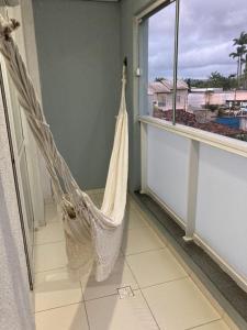 a hammock hanging in a room with a window at Apto amplo e confortável in Tijucas