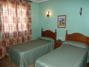 Duas camas num quarto com paredes azuis em Hotel Rural Miguel Rosi em Huércal-Overa