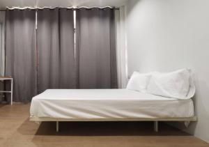 a bed with white sheets and pillows in a room at GO INN Pattaya in North Pattaya