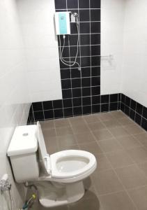 a bathroom with a toilet and a black tiled wall at GO INN Pattaya in Pattaya North