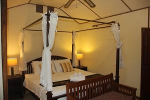 a bedroom with a canopy bed with white curtains at The Aerie in Pang Mapha