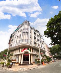 een groot wit gebouw aan de kant van een straat bij khách sạn Hồng Tâm in Ho Chi Minh-stad