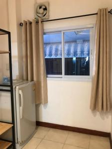 a kitchen with a window and a refrigerator at Kanokwan Guesthouse in Ko Tao