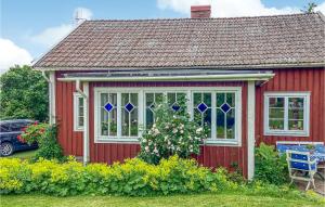 uma casa vermelha com uma cadeira azul em frente em 4 Bedroom Cozy Home In Ells em Ellös