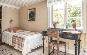 1 dormitorio con cama, escritorio y ventana en 4 Bedroom Cozy Home In Ells, en Ellös
