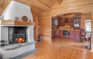 a living room with a fireplace in a log cabin at 3 Bedroom Nice Home In Hovet in Hovet