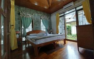sypialnia z łóżkiem w pokoju z oknami w obiekcie Pirerukafu Villa's - Villa Tipe Thailand di Kota Bunga Puncak w mieście Cimacan