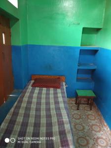 Un dormitorio con una cama con una pared azul y verde en Yatri niwas home stay en Varanasi