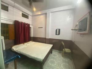 um quarto de hospital com uma cama e uma cadeira em Yatri niwas home stay em Varanasi