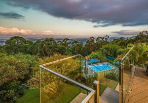 a house with a glass balcony and a swimming pool at Coastline: Alpine Villa in Mount Tamborine