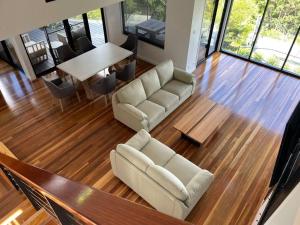 a living room with a couch and a table at Coastline: Alpine Villa in Mount Tamborine
