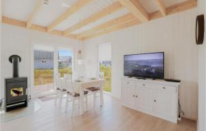 ein Wohnzimmer mit einem TV, einem Tisch und einem Kamin in der Unterkunft Awesome Home In Ostseeresort Olpenitz With Sauna in Olpenitz
