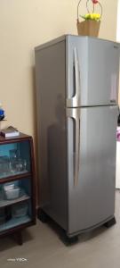 um frigorífico de aço inoxidável ao lado de um armário em HOMESTAY KAKMAH em Jasin