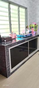 um balcão de cozinha com uma mesa com pratos em HOMESTAY KAKMAH em Jasin