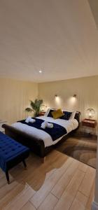 a bedroom with a large bed and a blue bench at Lily Pad by Paymán Club in Royston