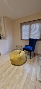 a room with a bed and a blue chair at Lily Pad by Paymán Club in Royston