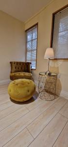 a living room with a yellow bean bag chair and a lamp at Lily Pad by Paymán Club in Royston