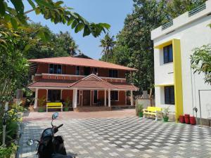 a house with a scooter parked in front of it at Quality Inn Varkala in Varkala