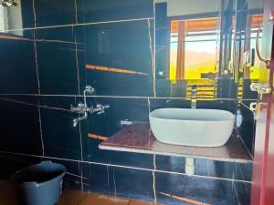 a blue tiled bathroom with a sink and a window at Memories of Malnad in Chikmagalūr