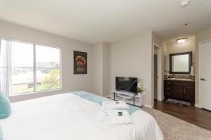 a bedroom with a large white bed and a television at Sunset Strip 2 Bedroom 2 Bathroom with Pool & Views in Los Angeles