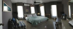 a bedroom with a bed in a room with windows at Klong Muang Beach Apartment in Klong Muang Beach