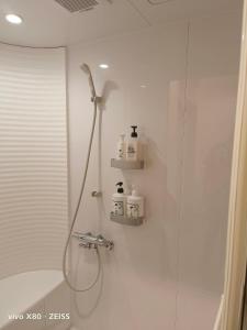 a bathroom with a shower and a glass shower stall at cafe&stay CASTANA in Matsumoto