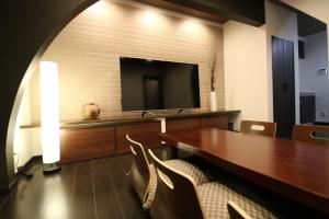 a room with a table with chairs and a television at Yadoya Matsumoto Honjo - Vacation STAY 13372v in Matsumoto