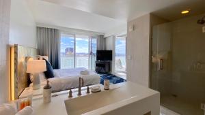 a bathroom with a sink and a bedroom with a bed at OneLuxStay at W Residences in Fort Lauderdale