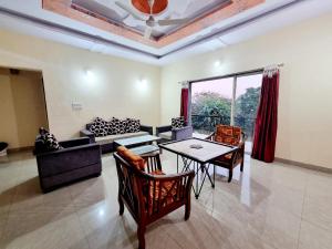 a living room with a table and chairs and a couch at RUDRASHREE VILLA - Besides Valley View in Mahabaleshwar