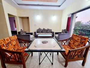 a living room with a table and chairs at RUDRASHREE VILLA - Besides Valley View in Mahabaleshwar +38 photos