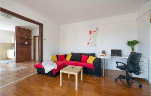 a living room with a red couch and a table at Beautiful Home In Peruski With Kitchen in Peruški