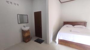 a bedroom with a bed and a sink and a mirror at Kristal Garden in Sekotong