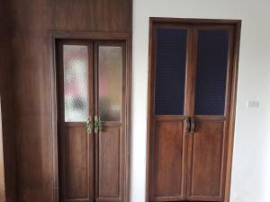a pair of wooden doors next to a wall at Dee Andaman Hotel in Krabi town