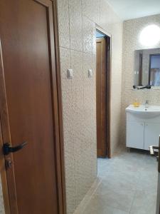 La salle de bains est pourvue de toilettes, d'un lavabo et d'une porte. dans l'établissement Vila Sunset, à Galaţi