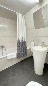 a bathroom with a tub and a toilet and a sink at Villa Zentrum Haus Davos in Davos