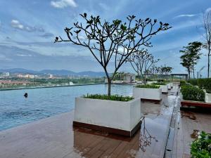 a row of white planters with a tree next to the water at Bangi Evo Luxury Suite in Bandar Baru Bangi