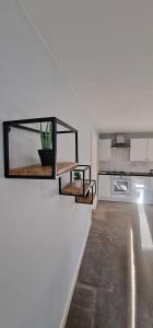 a white kitchen with some shelves on the wall at Maple by Paymán Club in Royston