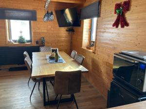 a dining room with a wooden table and chairs at Chata Snežienka in Litmanová