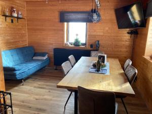 a living room with a wooden table and a blue couch at Chata Snežienka in Litmanová