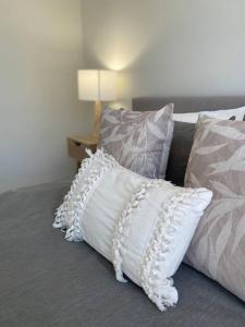 a group of pillows sitting on a bed at Bright 1 Bedroom Joondalup Stay in Perth