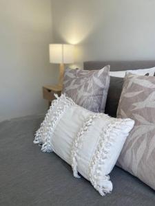 un grupo de almohadas sentadas en una cama en Bright 1 Bedroom Joondalup Stay, en Perth