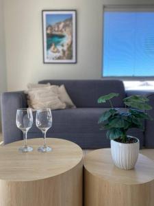 two round tables with wine glasses and a potted plant at Bright 1 Bedroom Joondalup Stay in Perth