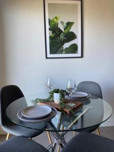 mesa de comedor con sillas y mesa de cristal con gafas en Bright 1 Bedroom Joondalup Stay, en Perth