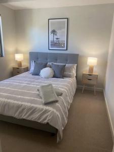 a bedroom with a large bed with two lamps at Bright 1 Bedroom Joondalup Stay in Perth