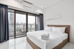 um quarto com uma cama grande e uma janela grande em Summer Suites KLCC Apartments by soulasia em Kuala Lumpur