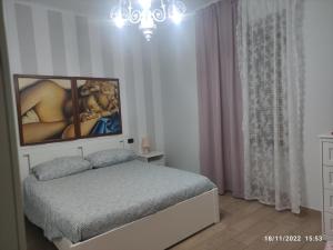 sypialnia z łóżkiem i obrazem na ścianie w obiekcie Certe notti w mieście Tarent