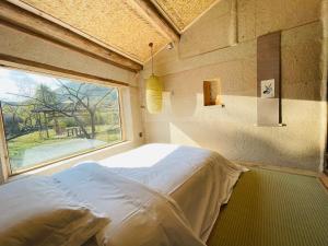 una camera con un letto in una stanza con una finestra di Pig's Inn Bishan Oil Factory a Yi