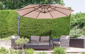 a patio with two chairs and an umbrella at Maison Des Rêves in Saint-Cézaire-sur-Siagne