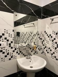 un baño con lavabo y espejo en Hotel Adinova, en Kasol 107 fotos más